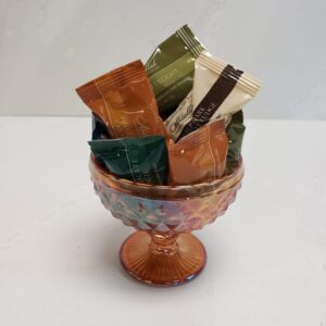 A small decorative dish with single wrapped chocolates