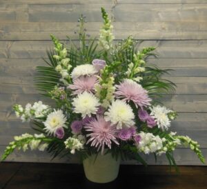 Large sympathy arrangement in whites and lavenders with robellini palm.