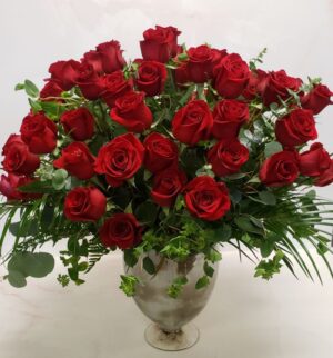 Six dozen red roses arranged in a grand container with bupleurum and eucalyptus.