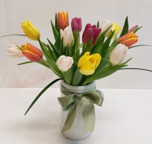 Small arrangement of multiple colored tulips finished with a green bow