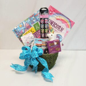 A gift basket full of unicorn themed gifts adorned with a big bow.