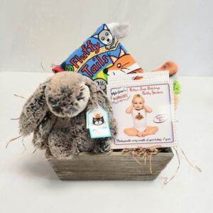 A wooden gift box with a Jellycat plush and activity book, and achievement trackers.