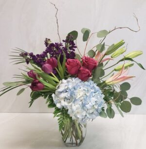 A romantic mixed floral arrangement with hydrangea, tulips, and lilies.