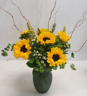 A small sunflower arrangement with bupleurum and curly willow in a textured vase