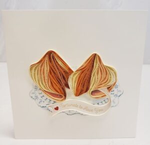 A 6"x6" quilling card that says, "Fortunate to have you." Featuring quilled fortune cookies in shades of brown.