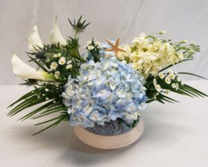a chic arrangement of blues and whites in a ceramic container with a keepsake starfish.